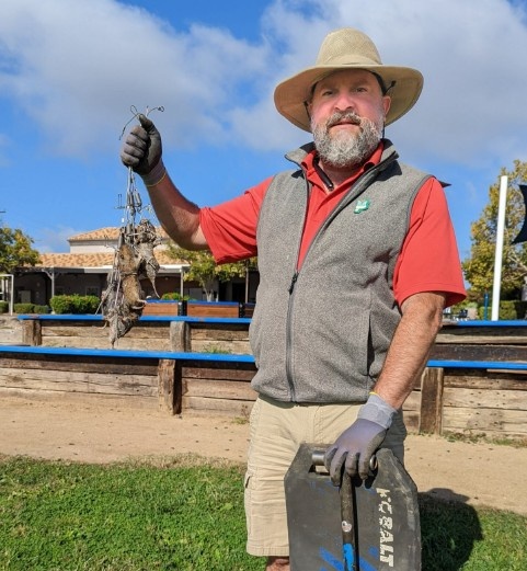 Gopher Stop technician holding a trapped gopher at an Eastvale, CA property